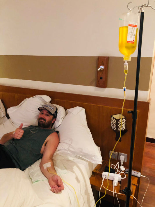 Patient giving thumbs up while receiving IV drip therapy in Bali hotel room - Ever Well Health